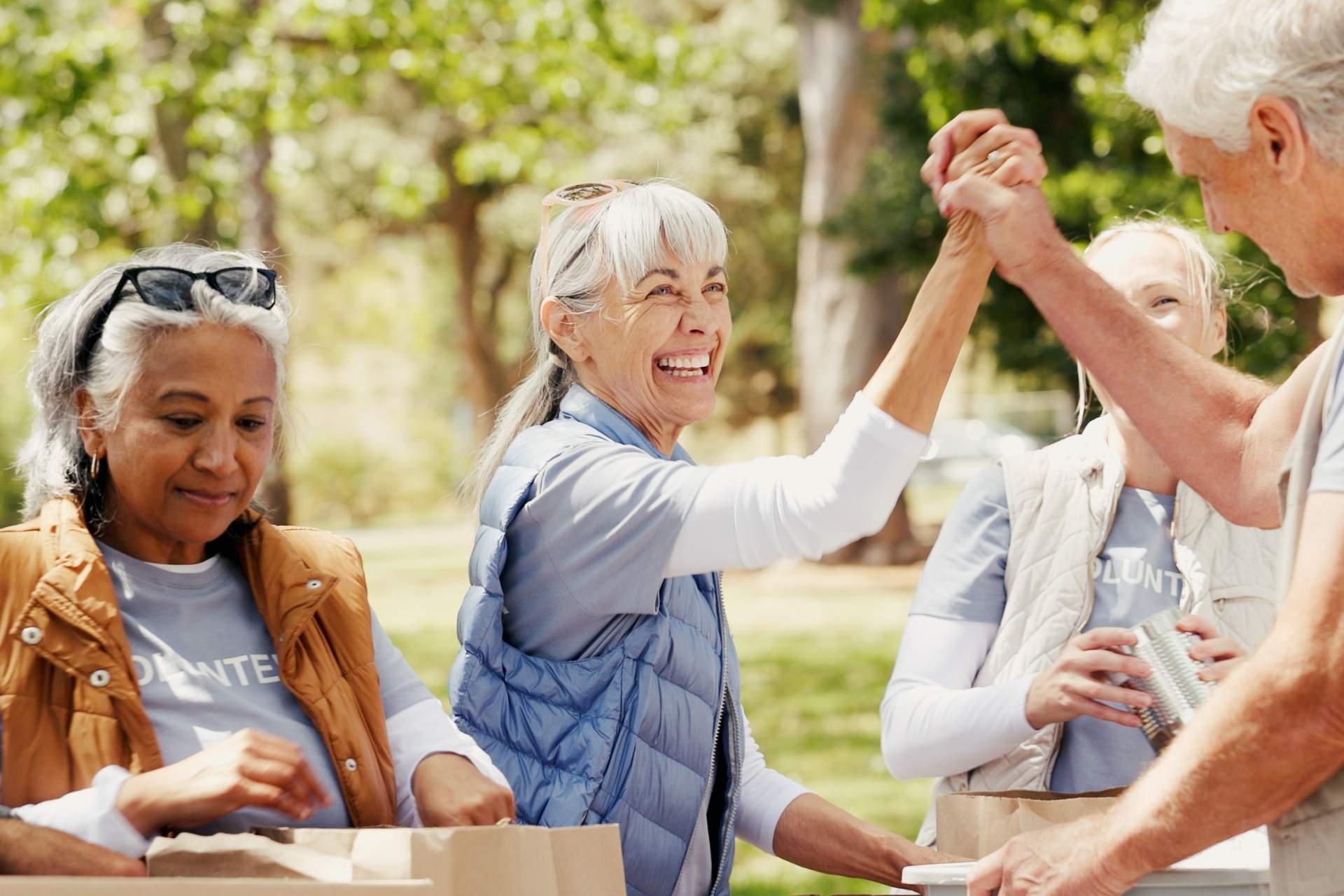 A group of seniors volunteering and high-fiving.